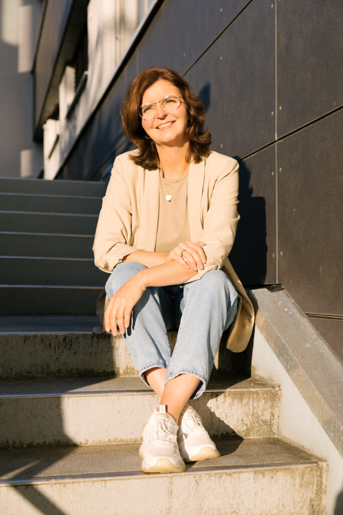 Fotografin Susanne Hauber auf Treppe in Weinstadt im Sonnenlicht