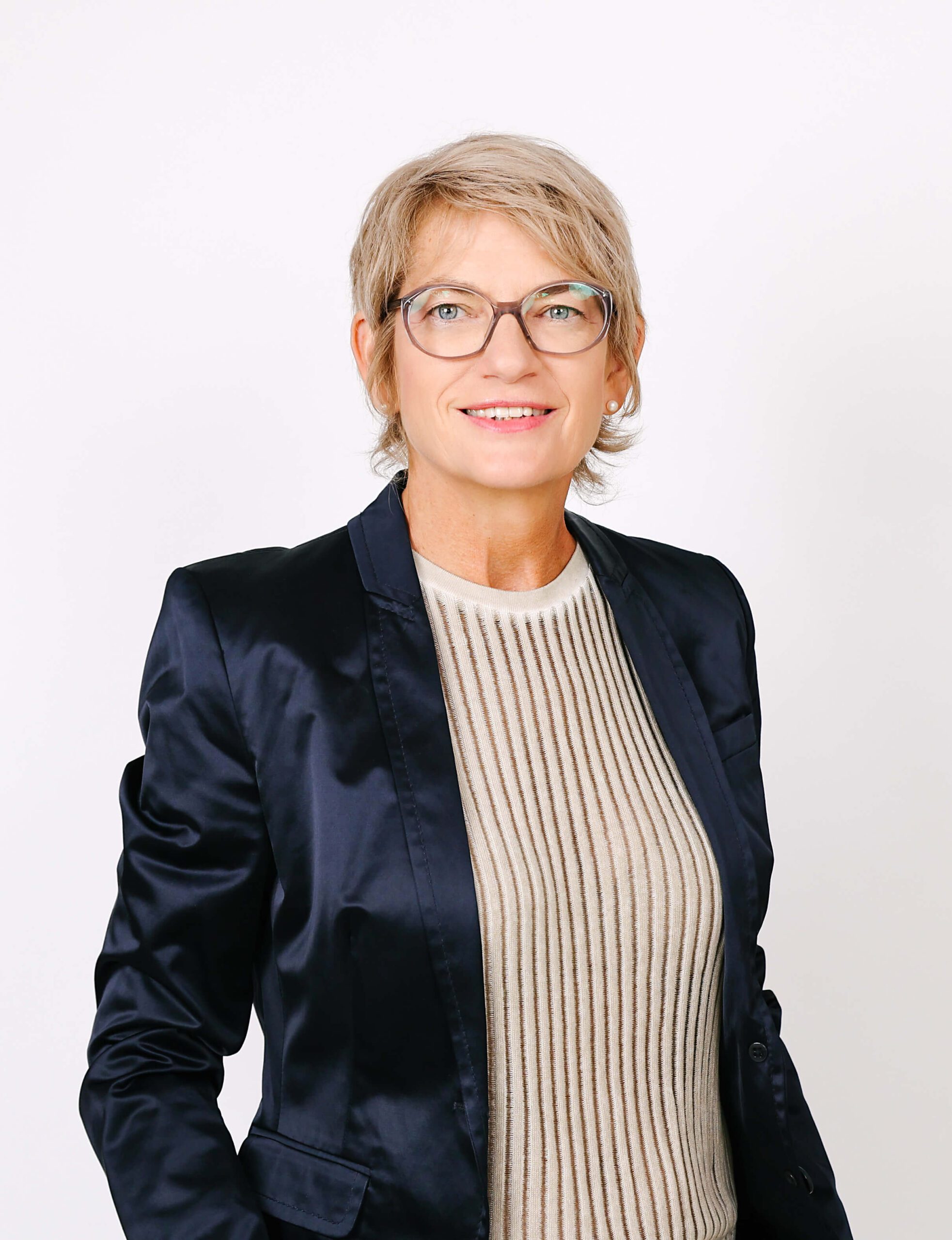 Business-Portrait vor weißem Hintergrund einer Frau mit blonden kurzen Haaren