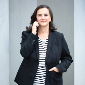 Businessfotografie Stuttgart – Frau in schwarzem Blazer hält Smartphone an ihr Ohr